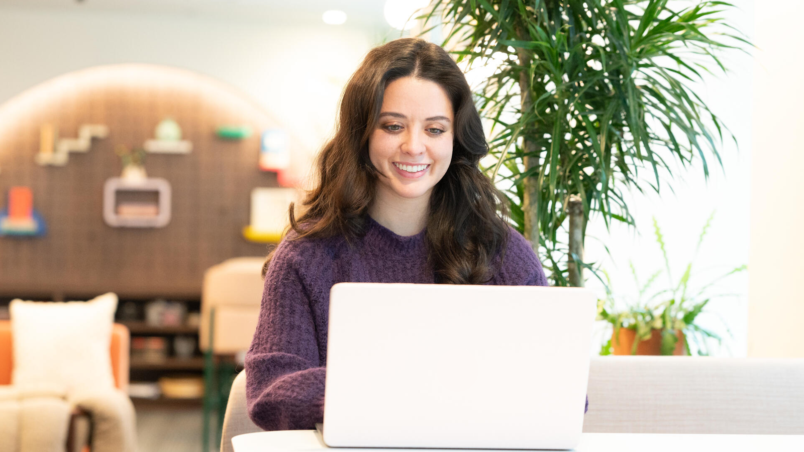a person sitting at a table with a laptop