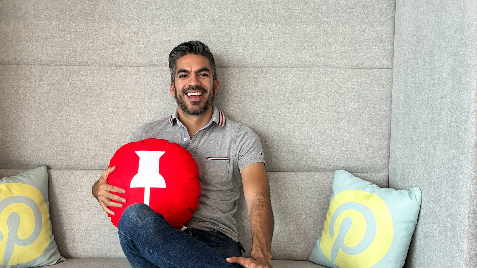 a man sitting on a couch holding a red ball