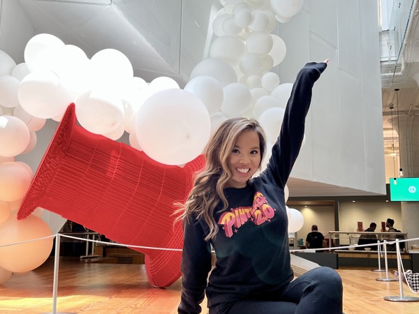 a person sitting on a wooden platform with white balloons