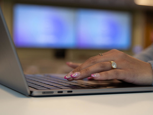 a hand on a laptop keyboard