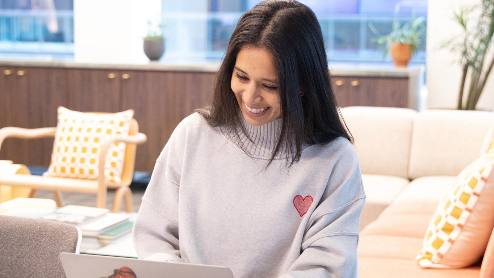 a person sitting at a table using a laptop