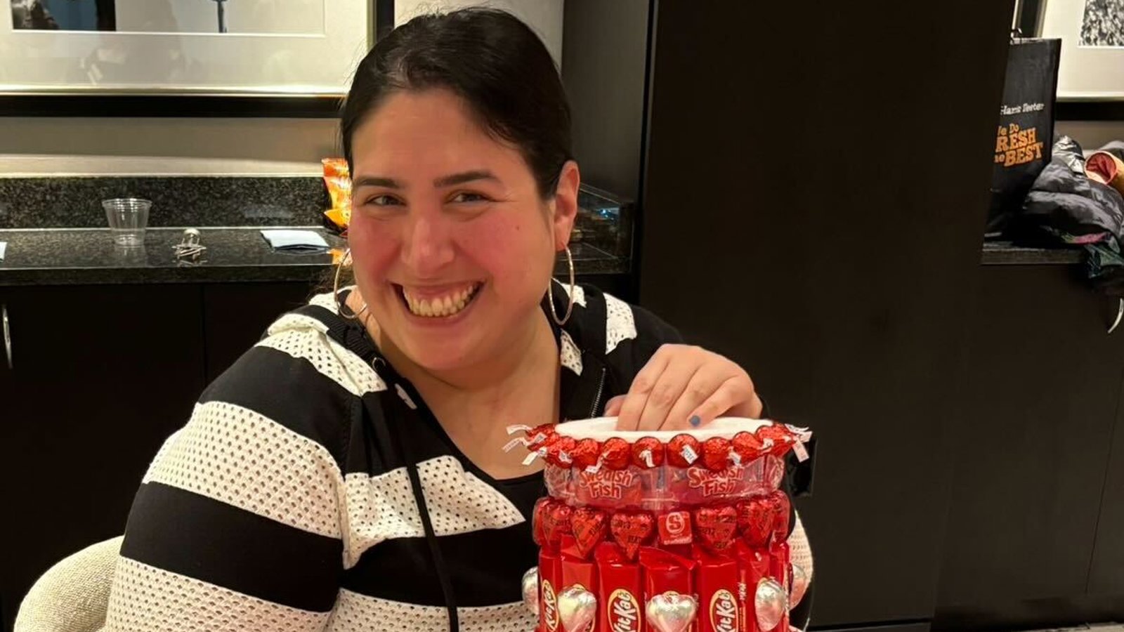 a woman smiling at a table with a cake