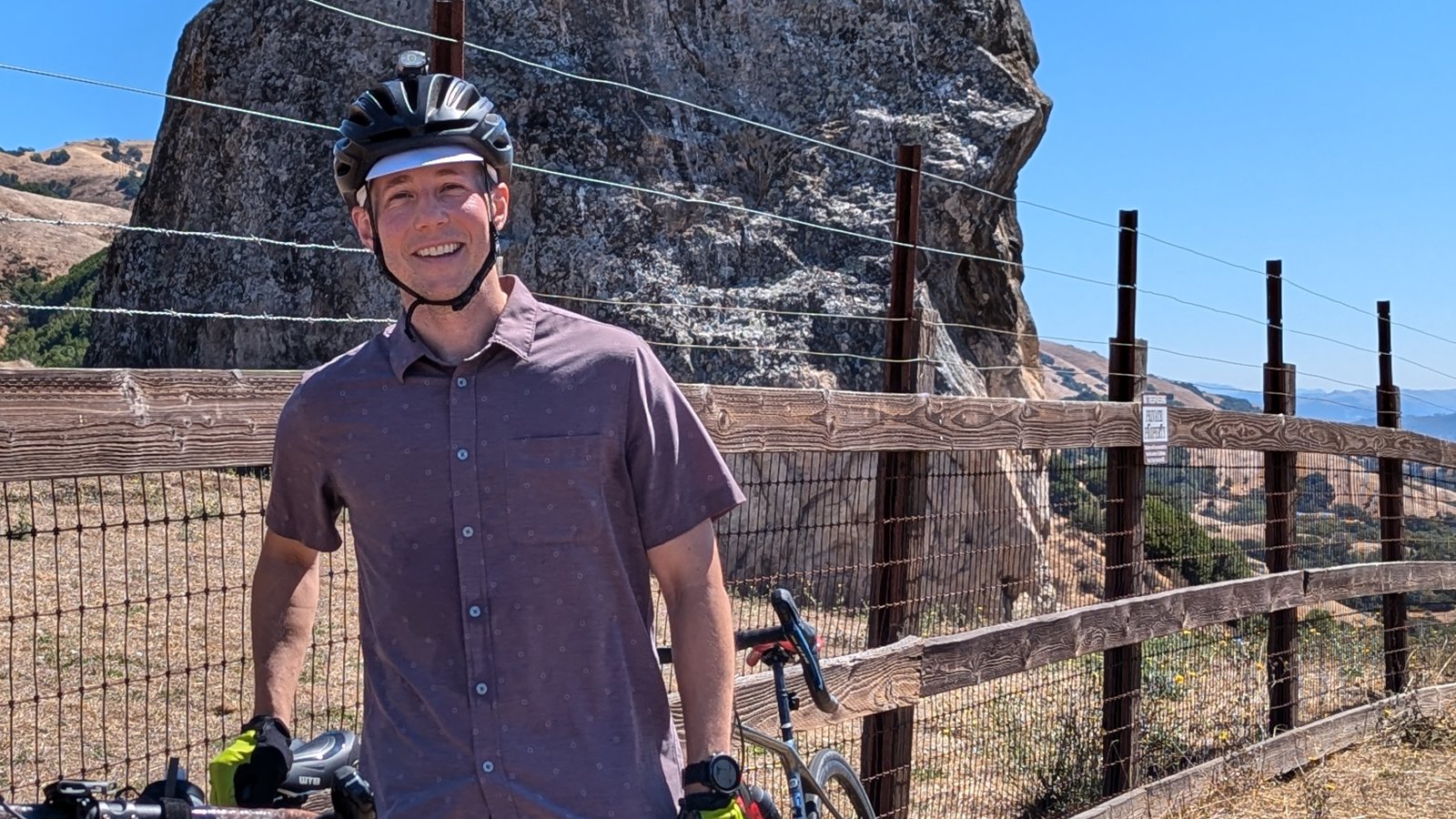 a person wearing a helmet and holding a bicycle