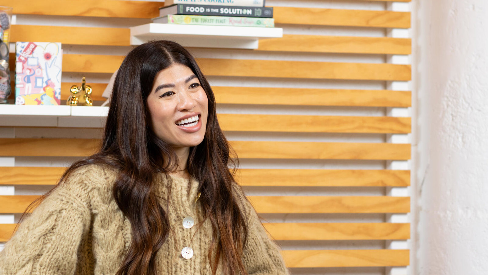 a woman smiling with her hands on her hips