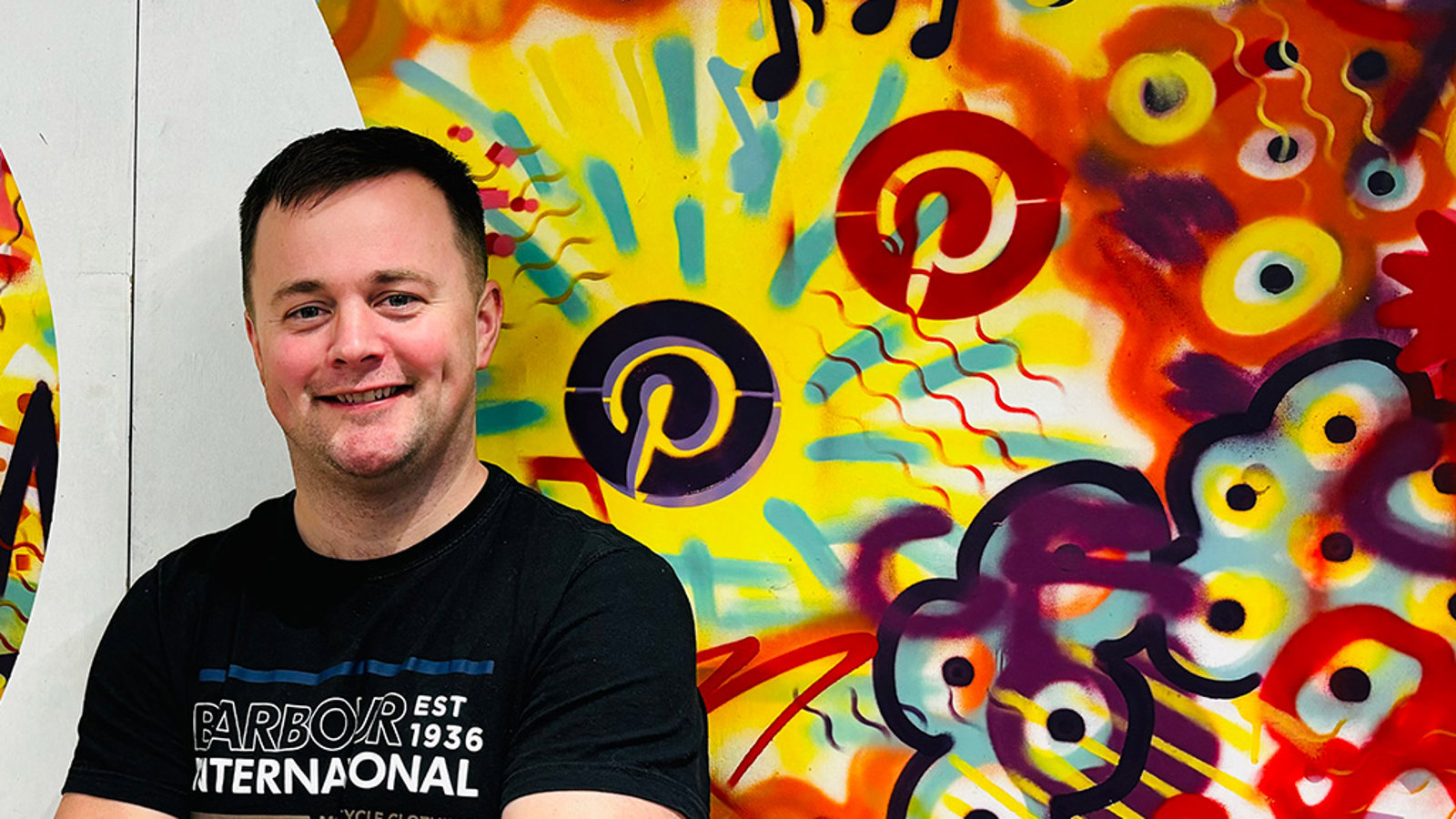 a man standing in front of a mural