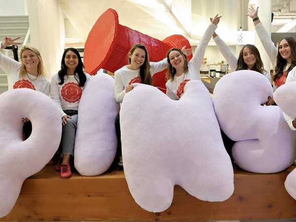 a group of people posing with large pillows