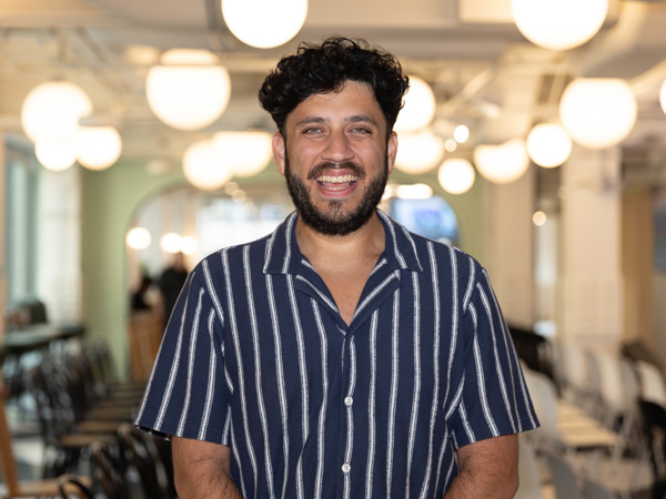 a person smiling in a room with chairs and lights