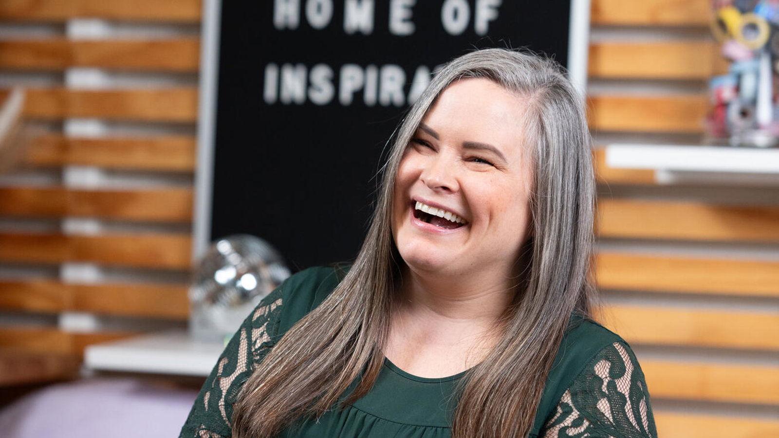 a person laughing in front of a chalkboard