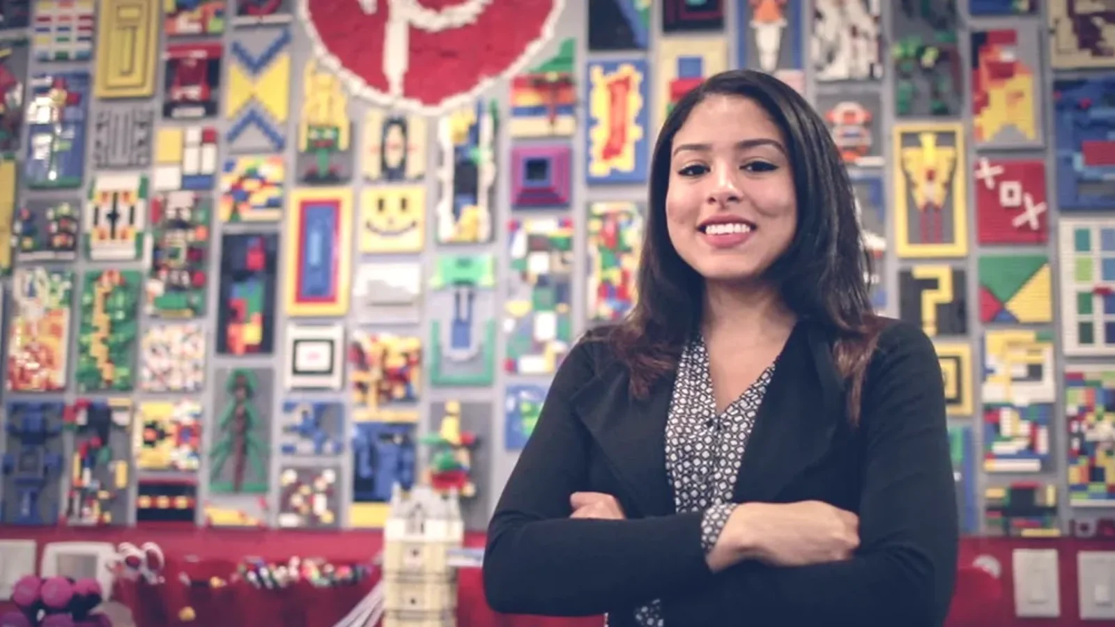 a person standing in front of a wall of lego pieces