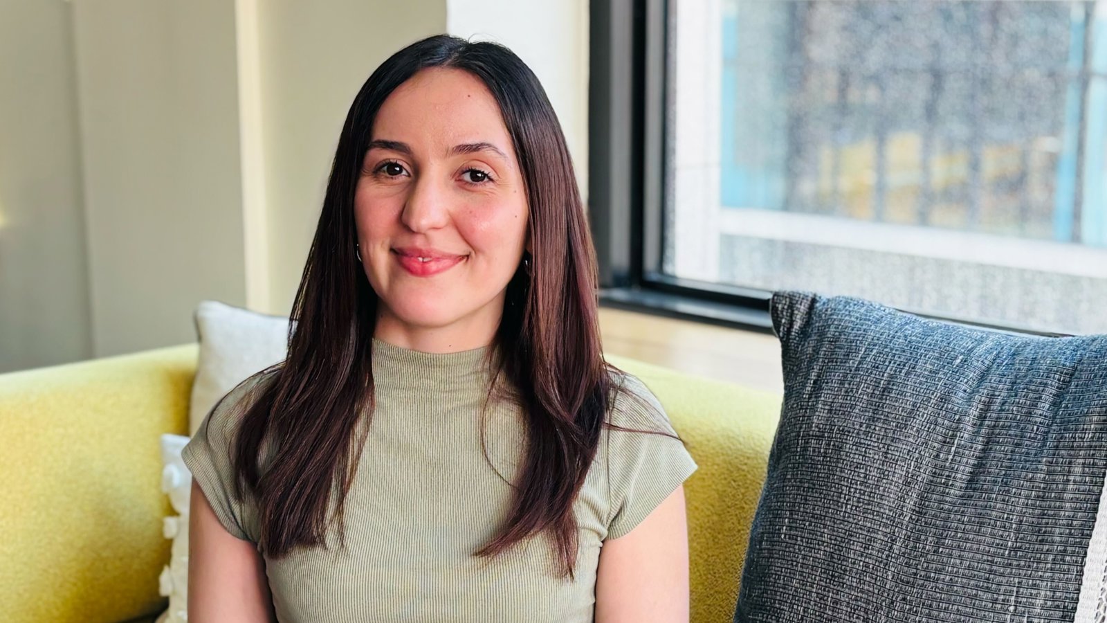 a person sitting on a yellow couch with a laptop