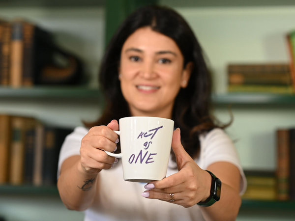 a person holding a white mug with writing on it