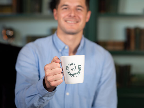 a man holding a white mug with writing on it