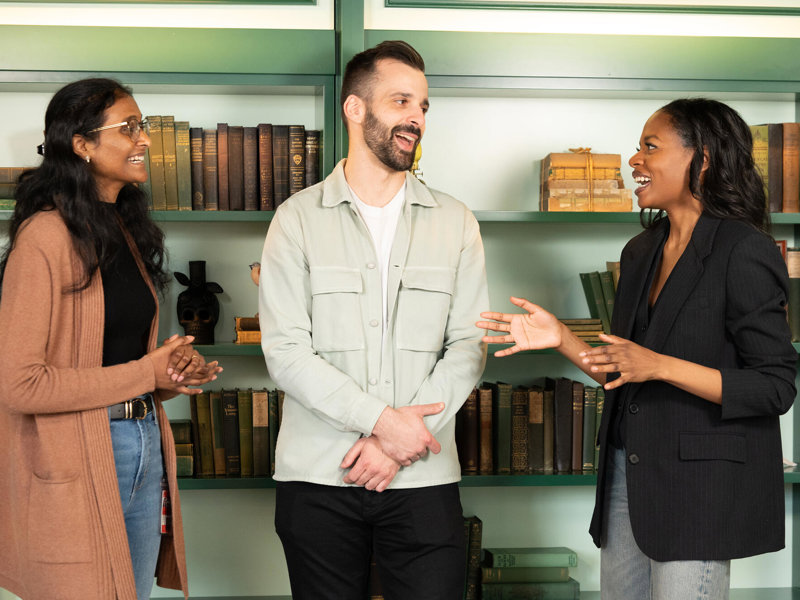a group of people standing in front of a bookshelf