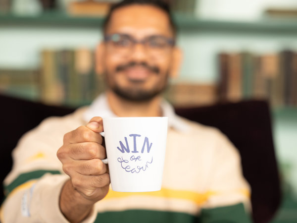 a man holding a white mug