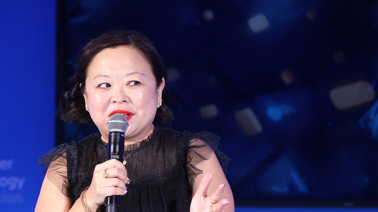 a woman in a black dress holding a microphone