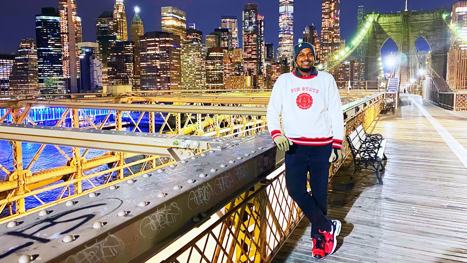 a man standing on a bridge with a city in the background