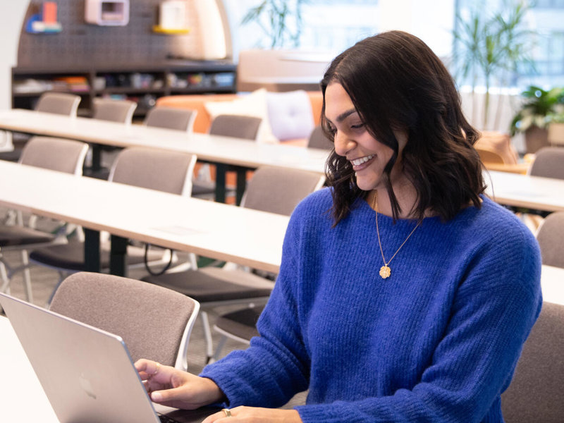 a person sitting at a table using a laptop