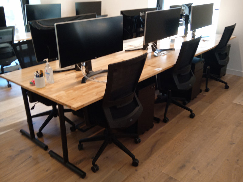 a desk with computers and chairs
