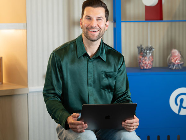 a person smiling while holding a laptop