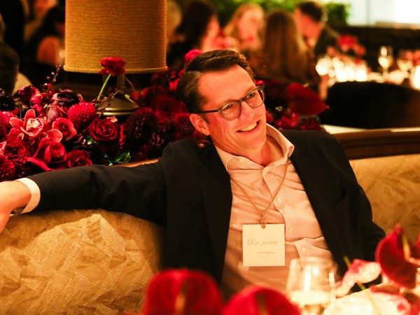 a person sitting on a couch with a bunch of flowers in the background