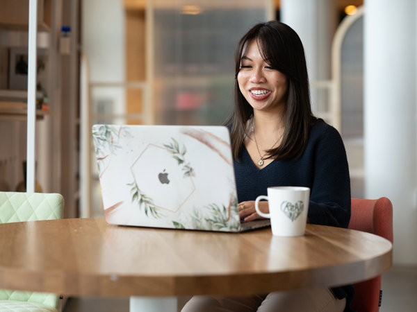 a woman sitting at a table with a laptop