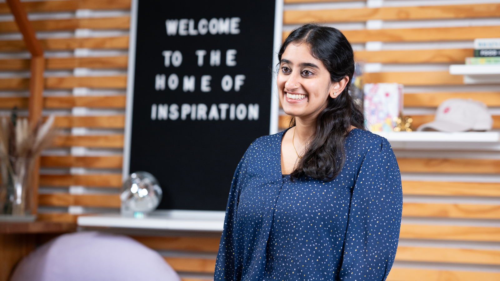 a woman smiling in front of a chalkboard