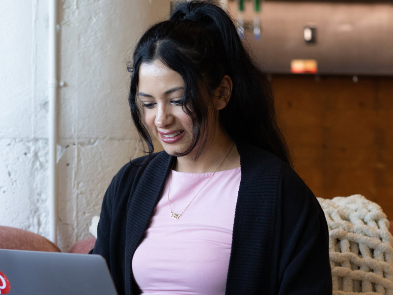 a woman sitting on a couch using a laptop