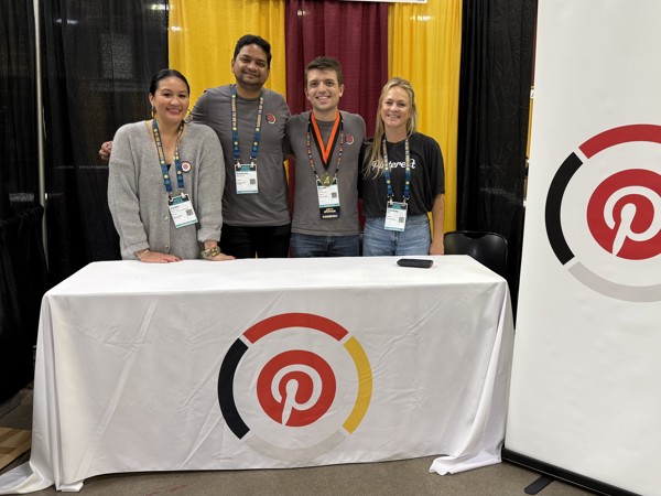 a group of people standing in front of a table with a white tablecloth