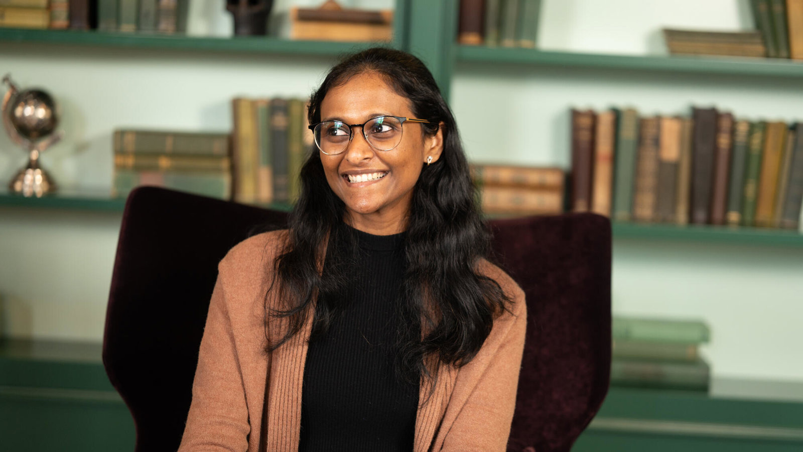 a woman smiling in a chair