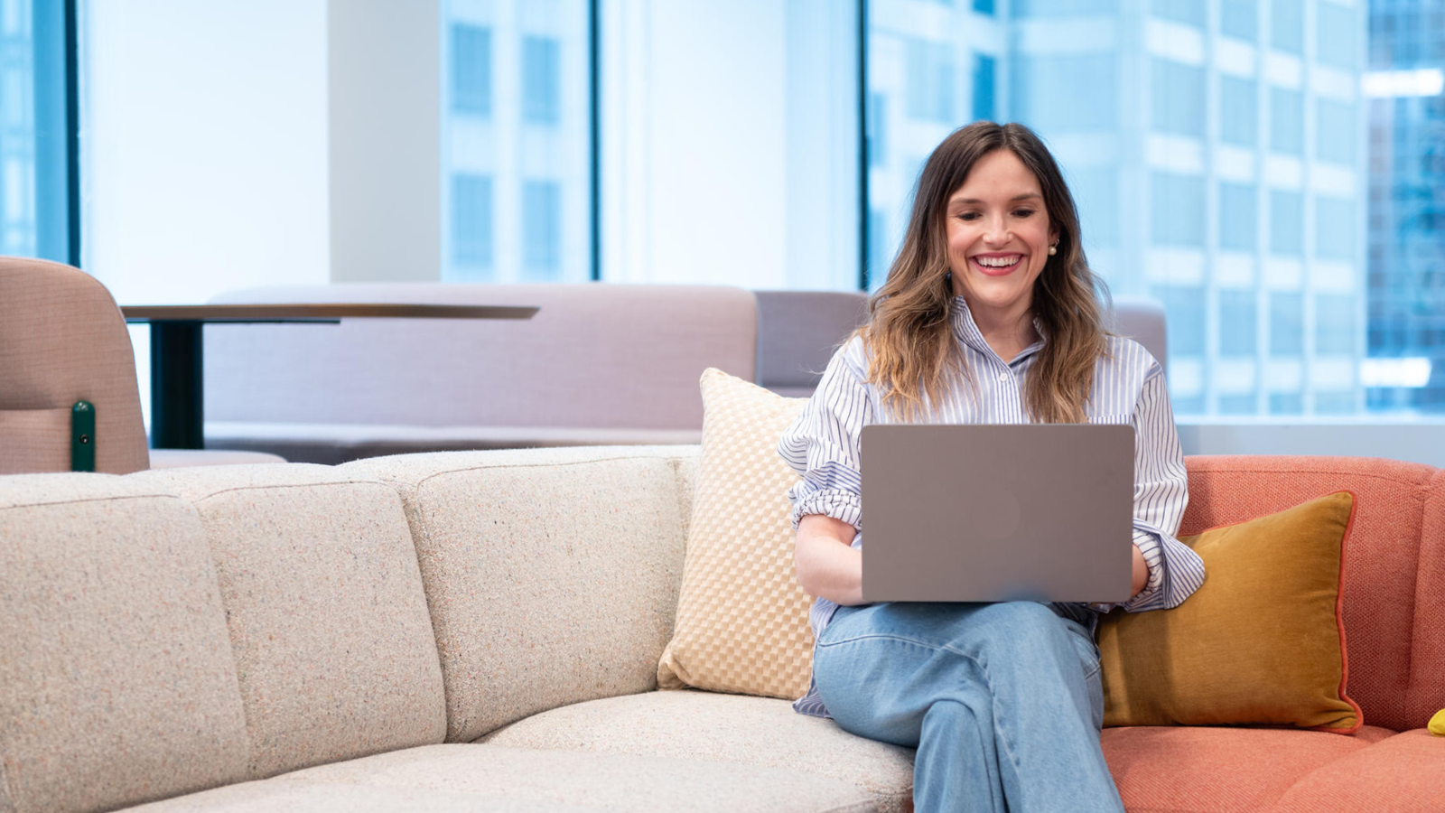 a person sitting on a couch using a laptop